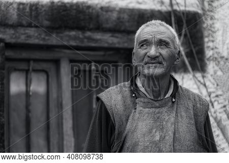 Stakna, India - August 26, 2015: A Senior Tibetan Monk With Wrinkled Face Looking Away At The Stakna