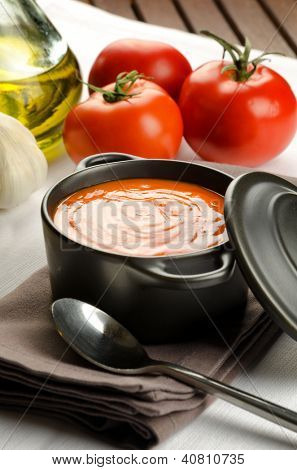 Soupe de tomate dans une casserole noire et ingrédients
