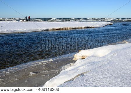 The Piasnica River During The Winter. Two Photographers With Tripod In Background. Baltic Sea, Debki