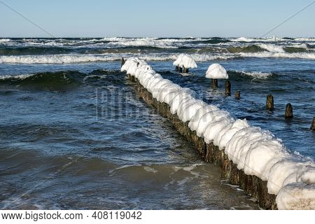 Snow Caps On Wooden Stakes At The Baltic Sea During Winter. Debki, Poland