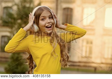 Girl Listening Music Modern Gadget. Kid Happy With Wireless Headset Outdoors Sunset Urban Background
