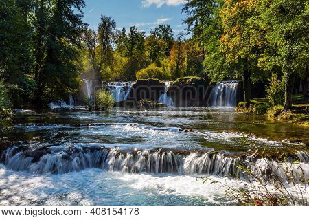 Magnificent cascade of waterfalls on the Korana River. The forest surround the river. The smal town of Slunj. Trip to Croatia. The concept of ecological, active and photo tourism