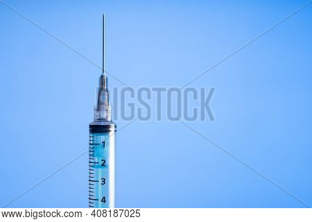 Syringe On Blue Background. Vaccine Preventions. Detail. Copy Space