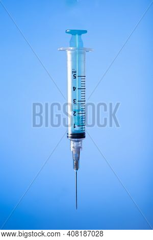 Syringe On Blue Background. Vaccine Preventions. Copy Space