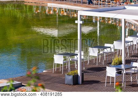 The Amalia Rodrigues Garden With A Pond Creating A Specular Reflection Of An Open Air Cafe.