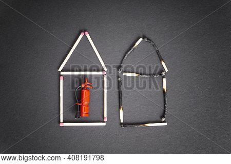 Two Houses Made Of Burnt And Unburnt Matches With A Miniature Fire Extinguisher Inside The Undamaged