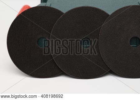 Abrasive Black Wheel, Grinding Wheel On The Background Of The Green Toolbox. Abrasive Materials, Dis