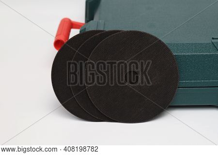 Abrasive Black Wheel, Grinding Wheel On The Background Of The Green Toolbox. Abrasive Materials, Dis