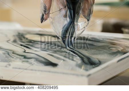 At The Workshop On Creating Fluid Art From A Plastic Cup, Black And White Resin Is Poured Onto The R