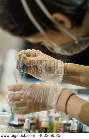Girl In A Mask And Transparent Gloves Close-up Capet With Paint From A Colored Bottle