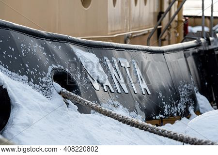 Riga, Latvia - February 9, 2021: Icy Hull With Mooring Hole And Ropes Tied To The Pier, Close-up