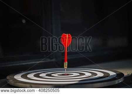 Dart Arrow Hit On Bulleyes Of Dartboard To Represent That The Business Reached The Target  With Dark