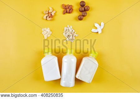 Alternative Types Of Vegan Milks In Bottles On A Yellow Background