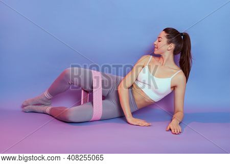 Adorable European Female Lying On Side With Bent Knees, Takes One Leg To Side, Exercise For The Inne