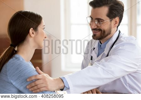Smiling 35s Male Doctor Telling Good News To Patient.