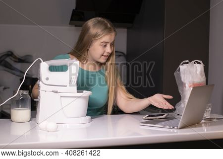 A Blonde Woman Chef Videoblogger Cooking In The Kitchen And Filming, Online Learning Or Remote Cooki