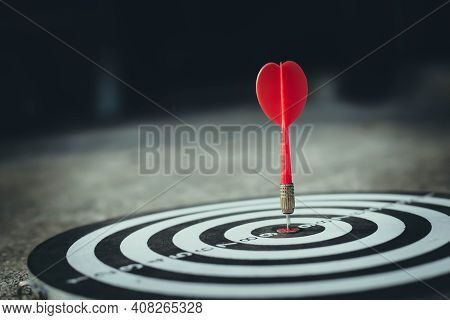 Close Up Shot Of The Dart Arrow Hit On Bulleyes Of Dartboard To Business. Dart Is An Opportunity And