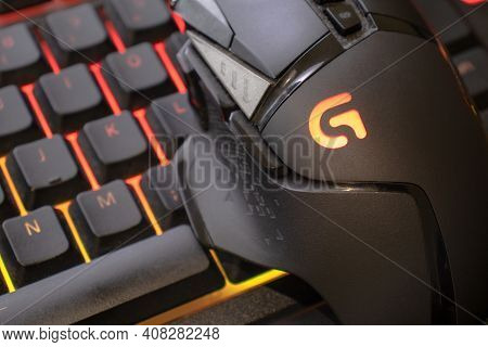 Logitech G502 Hero Gaming Mouse On Red Illuminated Gaming Keyboard, Close Up Shot. Devices To Play O