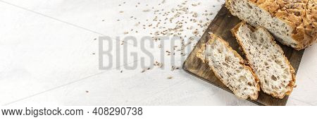 Banner With Siced Bread On Serving Board With Flax And Sunflower Seeds. Fresh, Tasty, Round Wheat Br