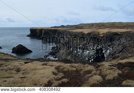 Lava Rock Cliffs And Basalt Columns On The Coast Of Iceland.