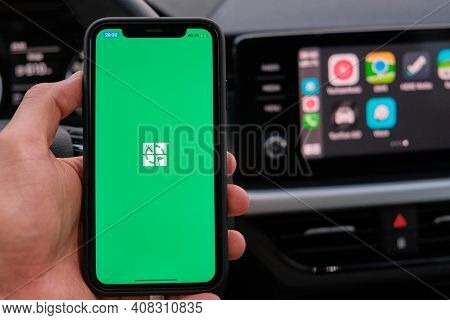 Xxx On The Screen Of Smart Phone In Mans Hand On The Background Of Car Dashboard Screen With Applica