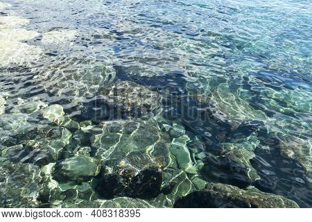 Rippled Transpatent Aquamarine Sea Water Surface Gleaming In Sunlight