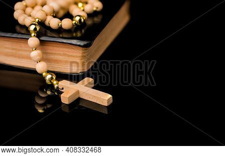 Closeup Of Wooden Christian Cross On Bible And Prayer Beads On Black.church Utensils.