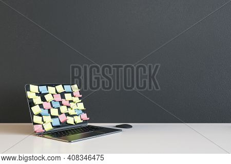 Opened Laptop With Colored Remider Sticks On Display On Light Empty Table At Dark Wall Background. 3