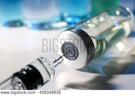 Filling Syringe With Vaccine From Vial On Table, Closeup