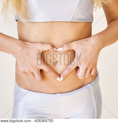 Young Woman Holding Hands Near Belly. Early Pregnant Concept. Gynecology Reproduction. Touch Stomach