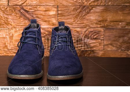 Footwear Ideas. Closeup Of Pair Of Mens Blue Suede Semi-brogue Boots Against Wooden Background Indoo