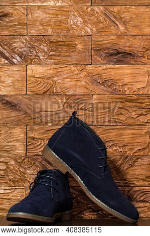 Closeup Of Pair Of Mens Blue Suede Semi-brogue Boots Against Wooden Background Indoors. Vertical Ima