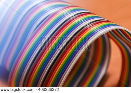 Roll Of Colorful Twisted Connecting Wire Strip On Plain Surface.