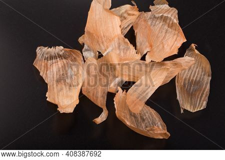 Brown Pieces Of Onionskin Isolated On Black.
