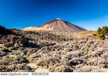 Silhouette Of Volcano Del Teide Against  Blue Sky And Female Hiker With Backpack. Pico Del Teide Mou
