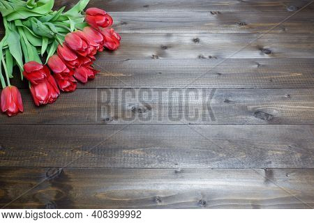 Frame Of Several Red Tulips On Wooden Table. Dark Wooden Panks Background. Womens Day, Spring, Love,