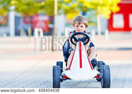 Active Little Kid Boy Driving Pedal Race Car In Summer Garden, Outdoors. Child Racing With Fast Spee