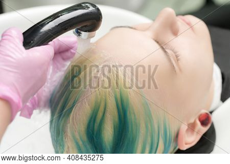 Professional Hair Salon, Hairstylist Washing Customer Head With Green Hair Color. Working Hairdresse