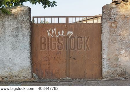 Rusty Door Of An Old Factory In Southern Spain, With A Nice Blue Sky