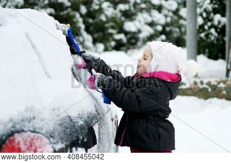 Child Brushing Snow Off Car.kid With Winter Brush And Scraper Clearing Family Car