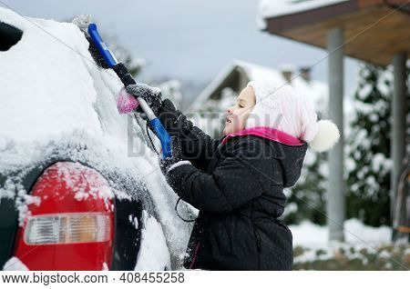 Child Brushing Snow Off Car.kid With Winter Brush And Scraper Clearing Family Car
