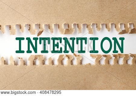 Intention. Text On White Paper Over Torn Paper Background.