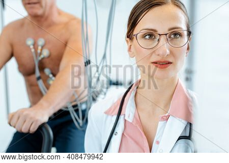 Doctor looking at screen of machine while patient has stress or exercise ECG