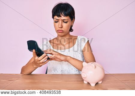 Beautiful brunettte woman caculating money savings depressed and worry for distress, crying angry and afraid. sad expression. 
