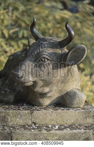 Kyoto, Japan - March 26 2020: Buddhist Stone Statue Of A Bull Lying With Coins Placed As An Offering