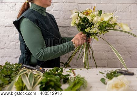 Florist Workplace On The Light Background. The Florist Creates A Floral Arrangement Of Roses, Lilacs