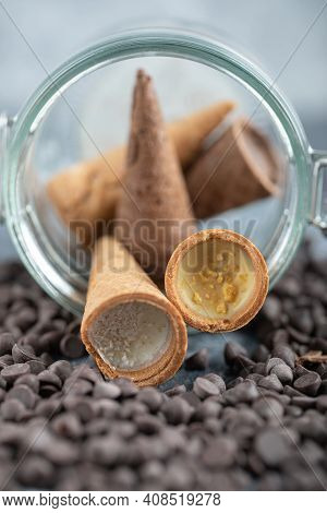 Sweet Conus Candy With Chocolate In Glass. Brown Background