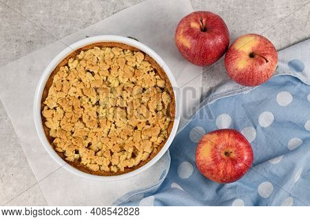 Top View Of Whole Traditional European Apple Pie With Topping Crumbles In White Springform Pan