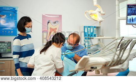Little Girl Patient Sitting In Stomatological Chair In Dental Office, Visiting Doctor For Oral Probl