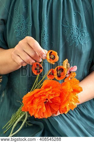 Woman In Green Dress Holding Poppe Flowers, Close Up On Her Hands. Spring Time Dreams.
